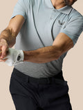 Three-quarter front view of a man wearing a light grey Club Graphic Polo with ombre print and Castore logo on the left chest.