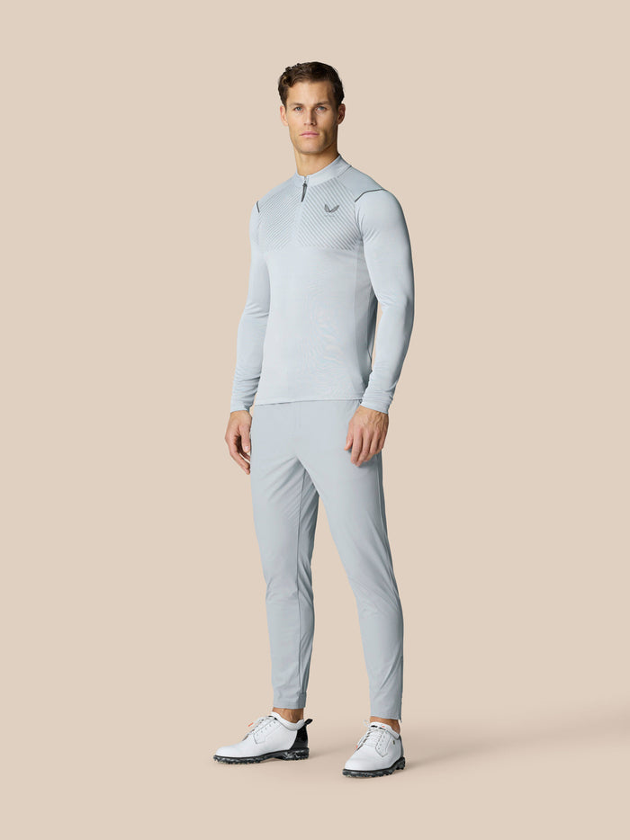 Full body view of a male model in Pinnacle LVS 1/4 Zip Top in Mid Grey with matching pants and white golf shoes.
