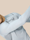 Model wearing Pinnacle LVS 1/4 Zip Top in Mid Grey with a quarter zip and ventilated knit panels.