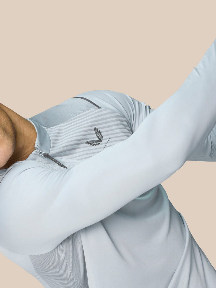 Model wearing Pinnacle LVS 1/4 Zip Top in Mid Grey with a quarter zip and ventilated knit panels.