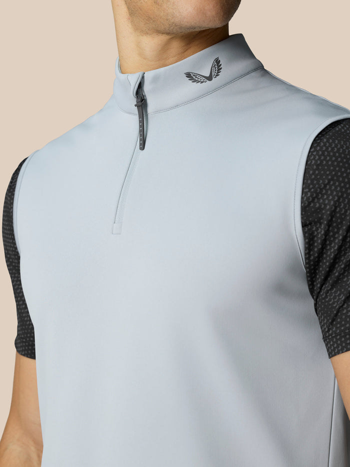Close-up of light grey golf gilet collar with half zip and Castore emblem