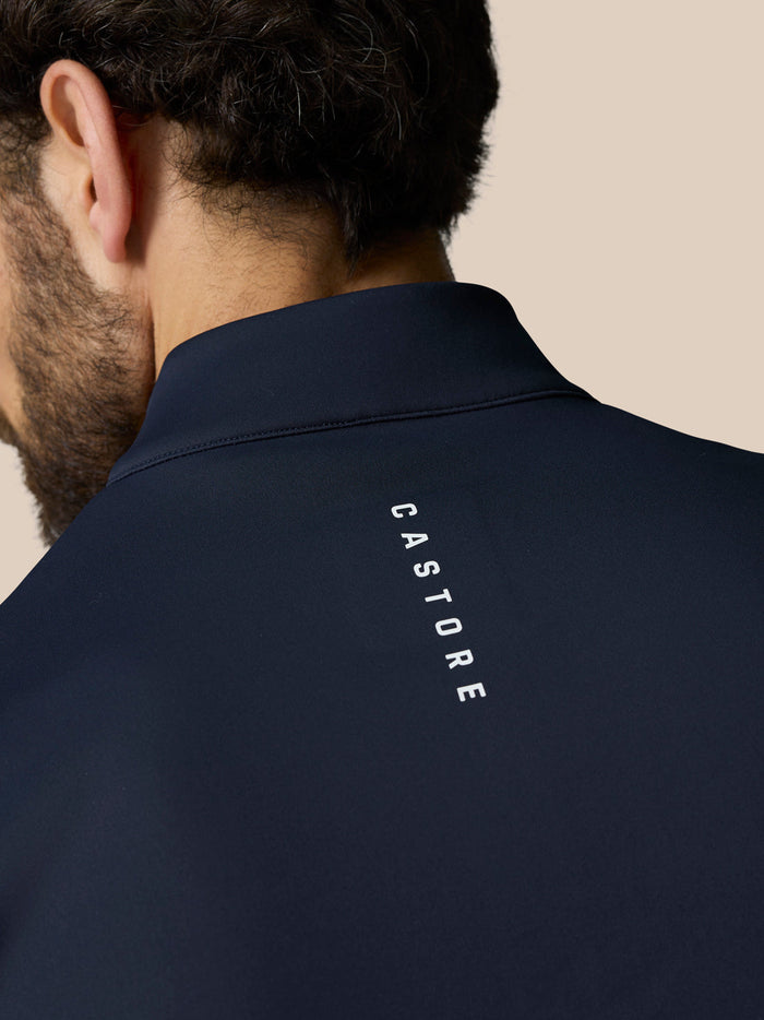 Back view of navy Castore jacket with the Castore logo running vertically along the neck