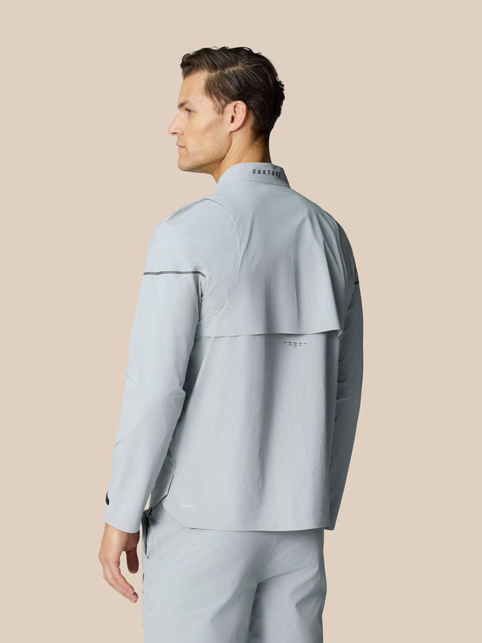 Back view of male model in light grey Golf Pinnacle LVS Woven Jacket showing vent panel and CASTORE collar