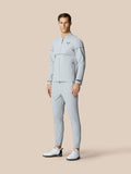 Full length shot of a male model in a matching light grey Golf Pinnacle LVS Woven Jacket and pants with white golf shoes
