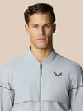 Male model wearing light grey Golf Pinnacle LVS Woven Jacket with zip front and chest logo