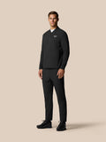 Full-body model in a black Castore golf outfit featuring winterized trousers and a matching jacket