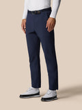 Model wearing midnight navy golf winter trousers with a black belt and white top