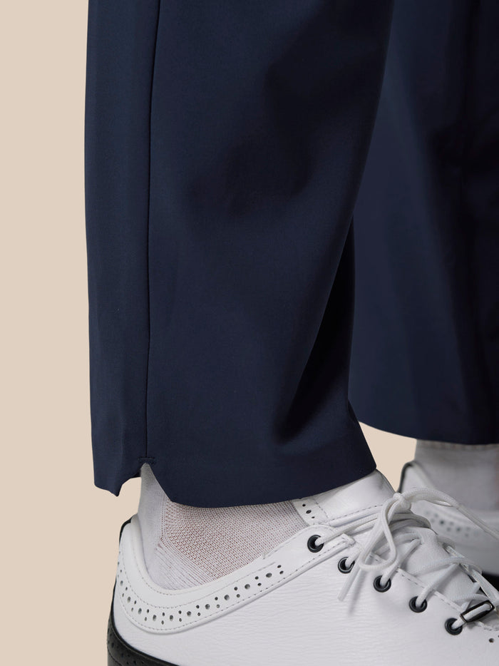 Close up of midnight navy Golf Pinnacle Winter Trousers leg with a white golf shoe.