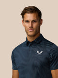 Close-up of Castore logo on the left chest of the striped Midnight Navy Golf Pinnacle Glow Polo.