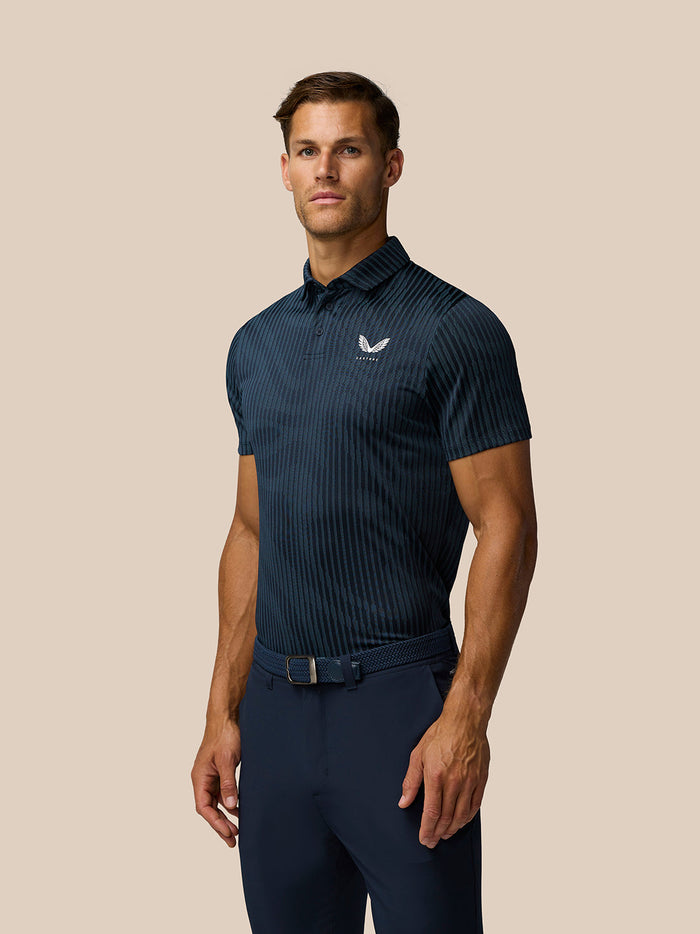 Man wearing Golf Pinnacle Glow Polo in midnight navy with striped knit and Castore logo on left chest