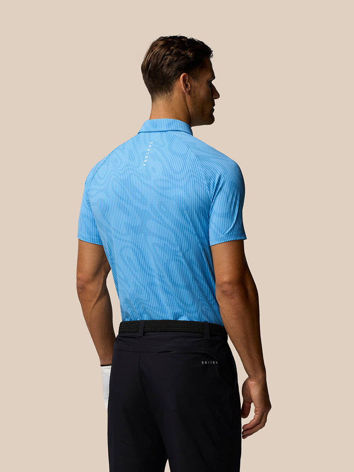 Back view of male model wearing light blue Golf Club Glow Printed Polo showing the subtle allover pattern