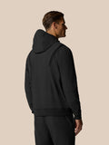 Back view of model in black Golf Pinnacle Performance Hoodie with hood up