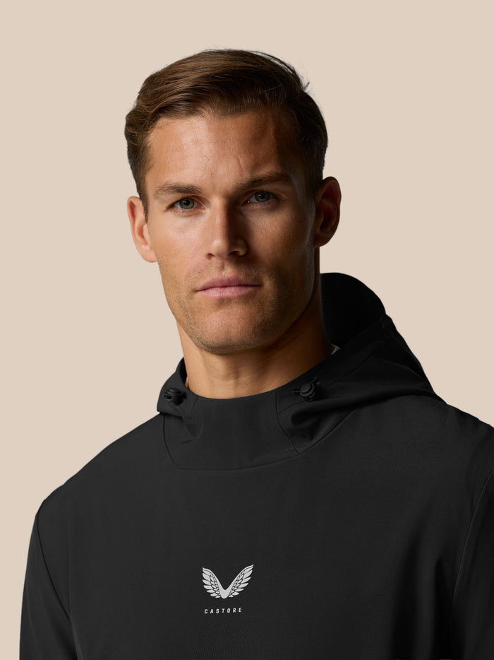 Close-up of Castore winged logo centered on the chest of a black hoodie fabric
