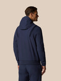 Back view of a male model in midnight navy golf performance hoodie with hood and panel details