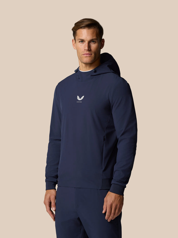 Male model wearing midnight navy Golf Pinnacle Performance Hoodie with hood down and Castore logo on chest.