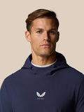 Close up of a man in the midnight navy Golf Pinnacle Performance Hoodie showing Castore logo centered on the chest.