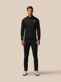Man wearing black all over print golf top with quarter zip and Castore logo on chest