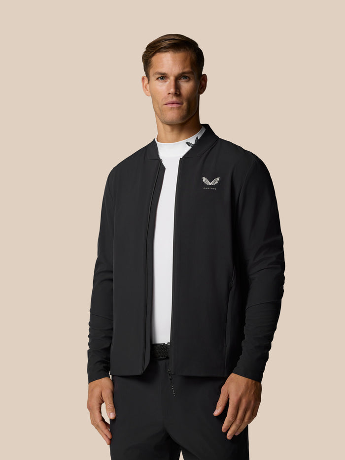 Male model in Golf Pinnacle LVS Winter Jacket in black with alloy accents and left chest logo