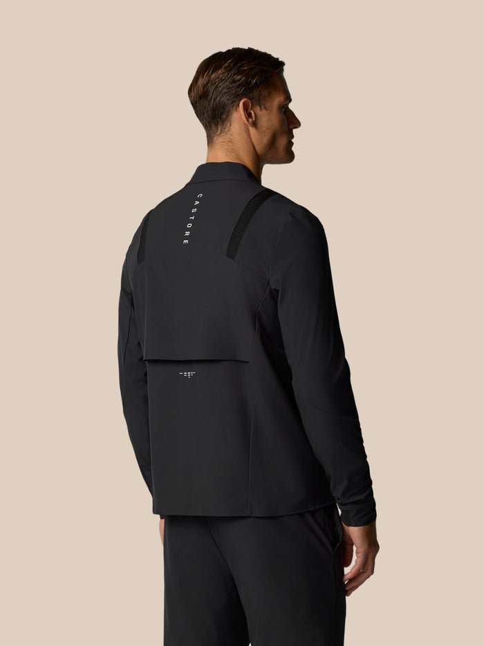 Back view of a man wearing a black Golf Pinnacle LVS Winter Jacket with vertical Castore branding down the back