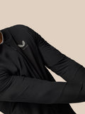 Side view of a man in a black Castore jacket with vertical CASTORE branding on the back near the shoulder.