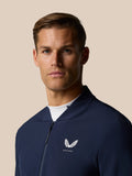 Front view of navy Castore jacket on a model showing the left chest logo and center front zipper