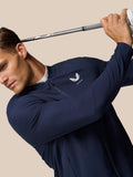 Male golfer wearing a midnight navy LVS Winter Jacket mid swing with a golf club.