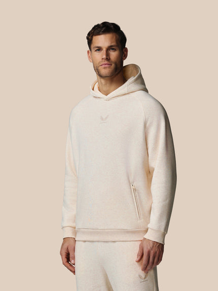 Man wearing a cream-colored hoodie against a beige background