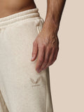 Beige sweatpants with a brand logo on a neutral background