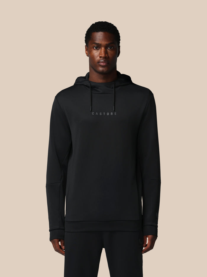 Man wearing a black hoodie with 'CASTORE' branding on a beige background