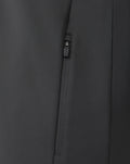 Close-up of a black zip pocket on performance fabric with a visible seam