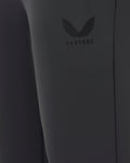 Close-up of a dark gray garment with a brand logo on a plain background