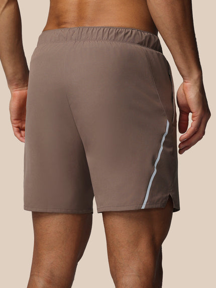 Brown athletic shorts with a white stripe on a beige background