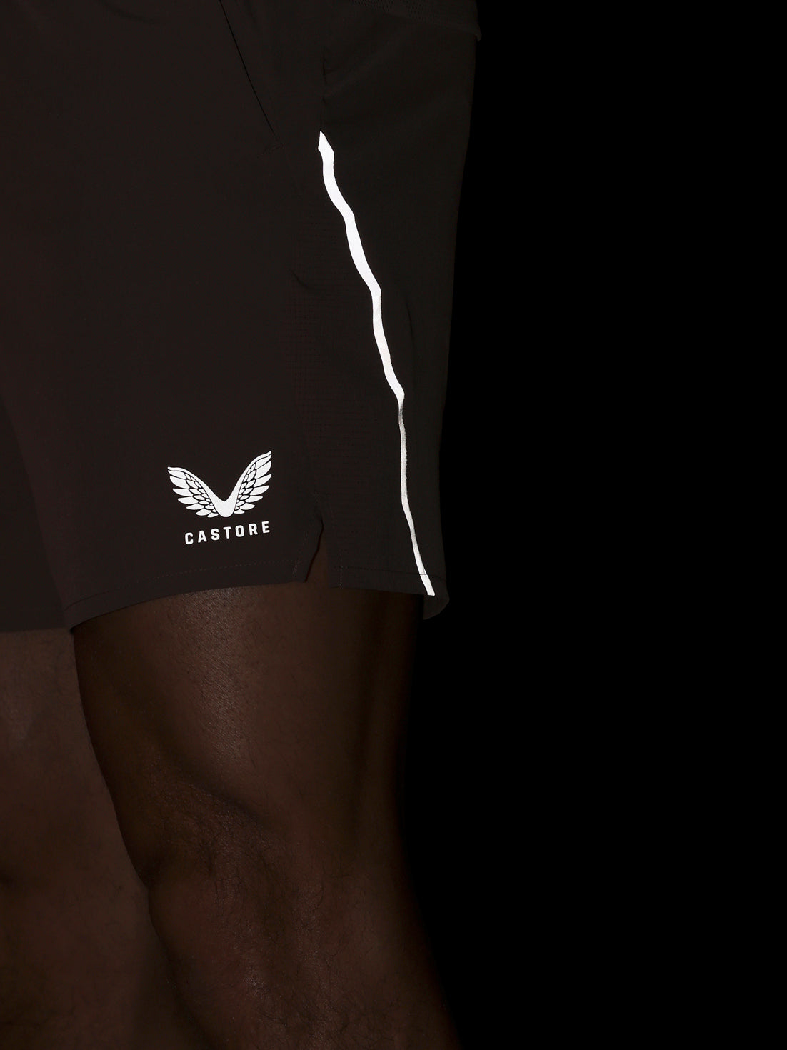 Brown athletic shorts with a white logo on a black background