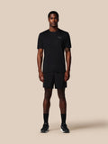 Man wearing a black t-shirt and shorts set on a beige background