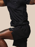 Person wearing black athletic shorts and shirt on a beige background