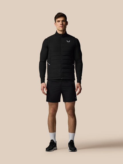 Man wearing a black jacket and shorts on a beige background