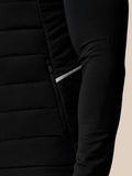 Close-up of a black puffer jacket with a beige background