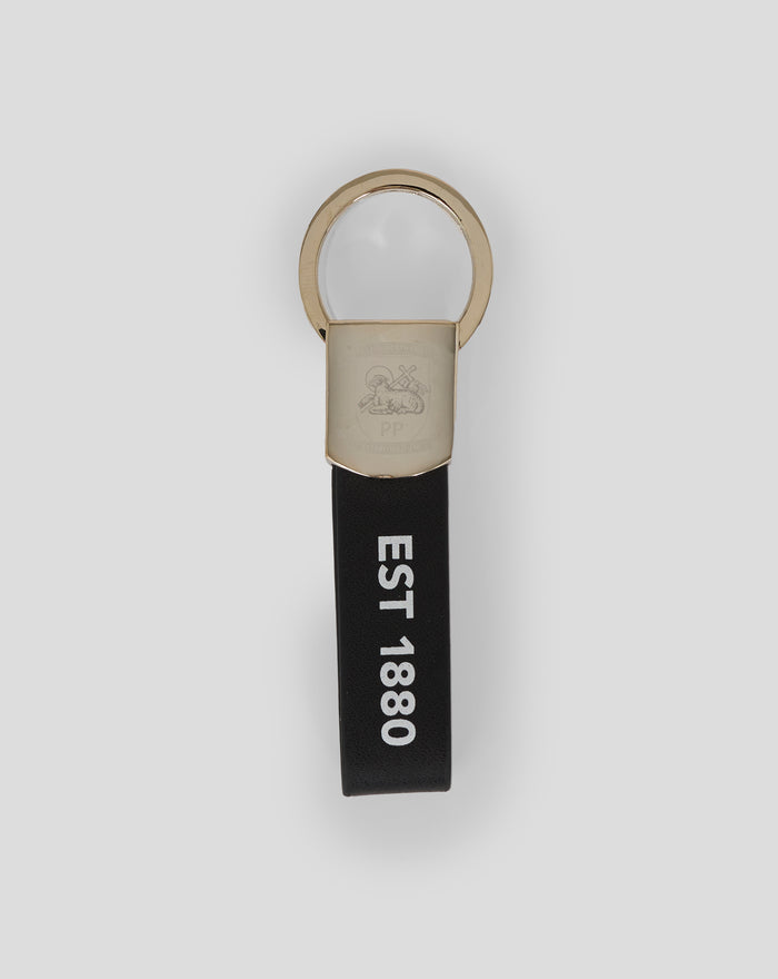 Gold metal loop keyring attached to a black PU leather strap with embossed crest and EST 1880
