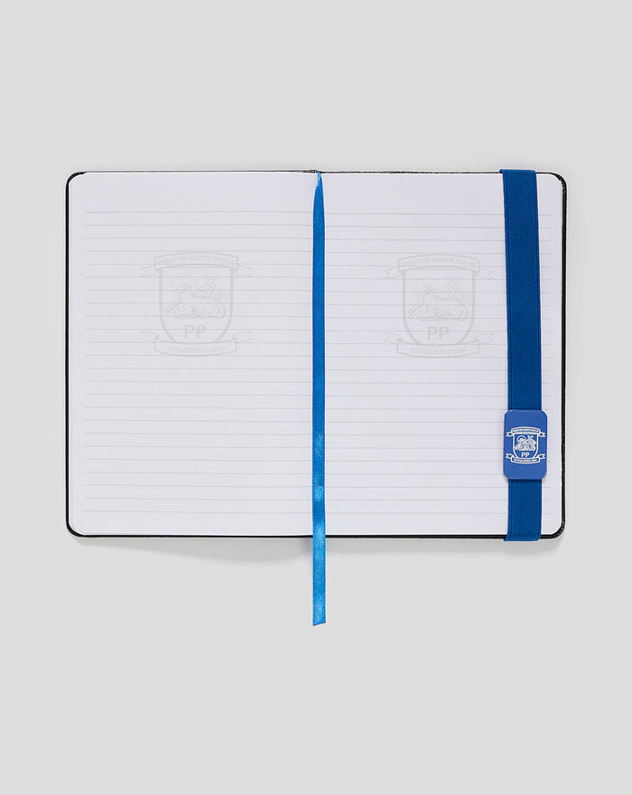 Open PNE A5 notepad with ruled pages and blue elastic strap along the right edge