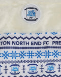 Close up of the cream stocking showing the club crest badge and blue pattern