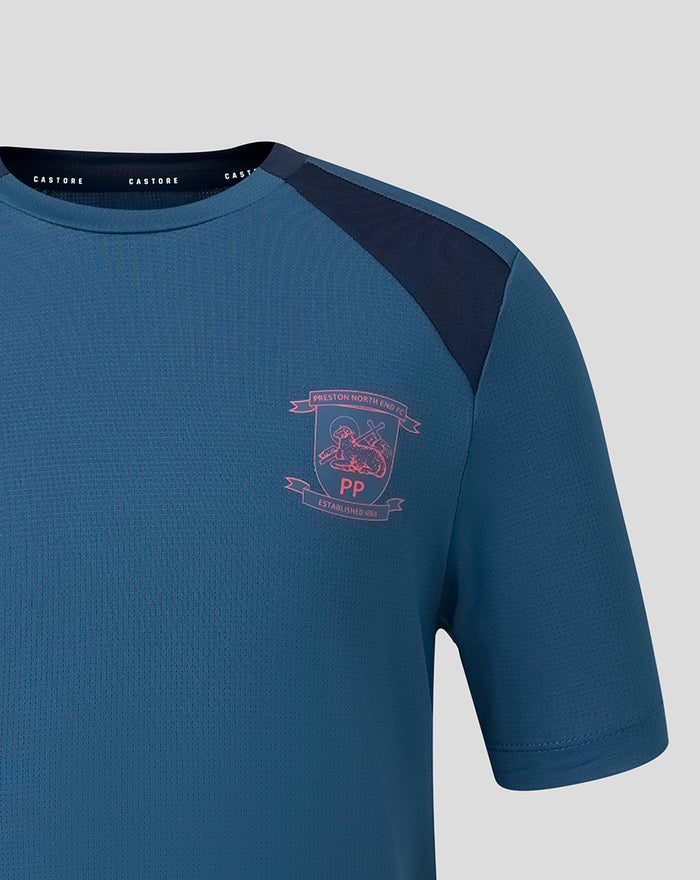 Left chest pink crest on blue training tee with navy shoulder panel