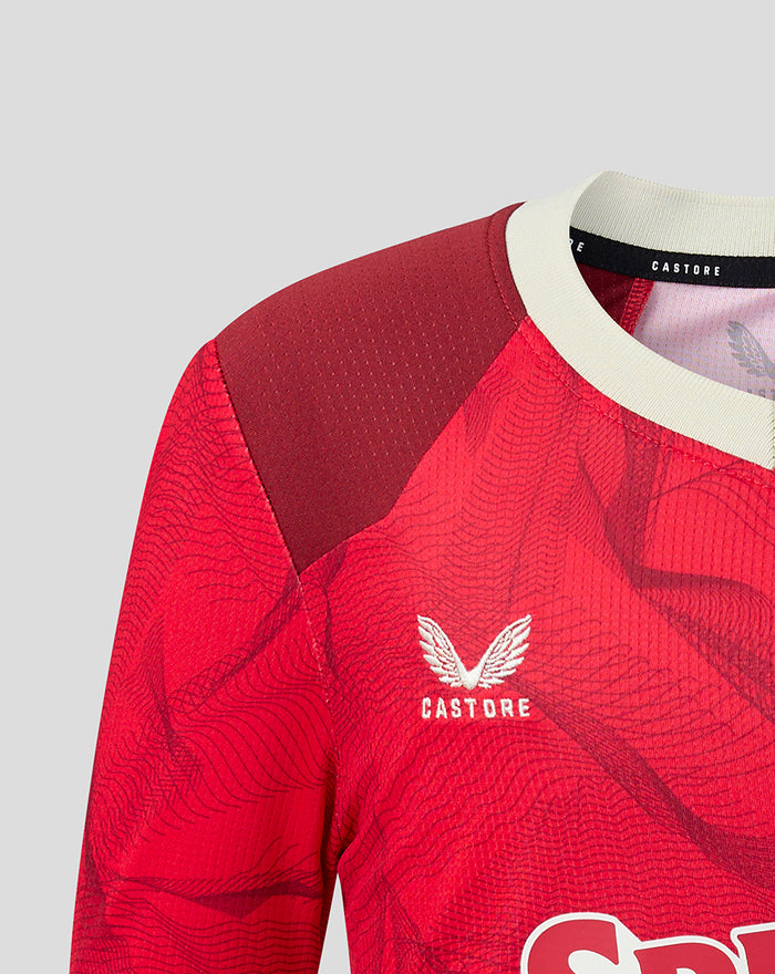 Close-up of red PNE Junior shirt chest area showing Castore logo and subtle textured pattern