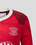 Red junior third shirt with white ribbed collar and team crest on chest