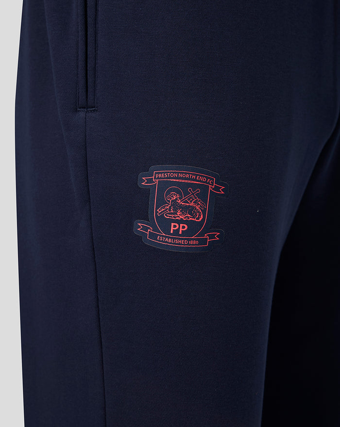 Close-up of navy fabric with Preston North End crest on the thigh.