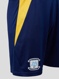 Side close up of PNE 26/27 home shorts showing beacon blue fabric with bold yellow stripe and crest near hem.