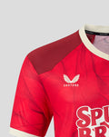 Close up of the red PNE 2026/27 third short sleeve shirt showing crest on chest and maroon shoulder panel with cream collar.