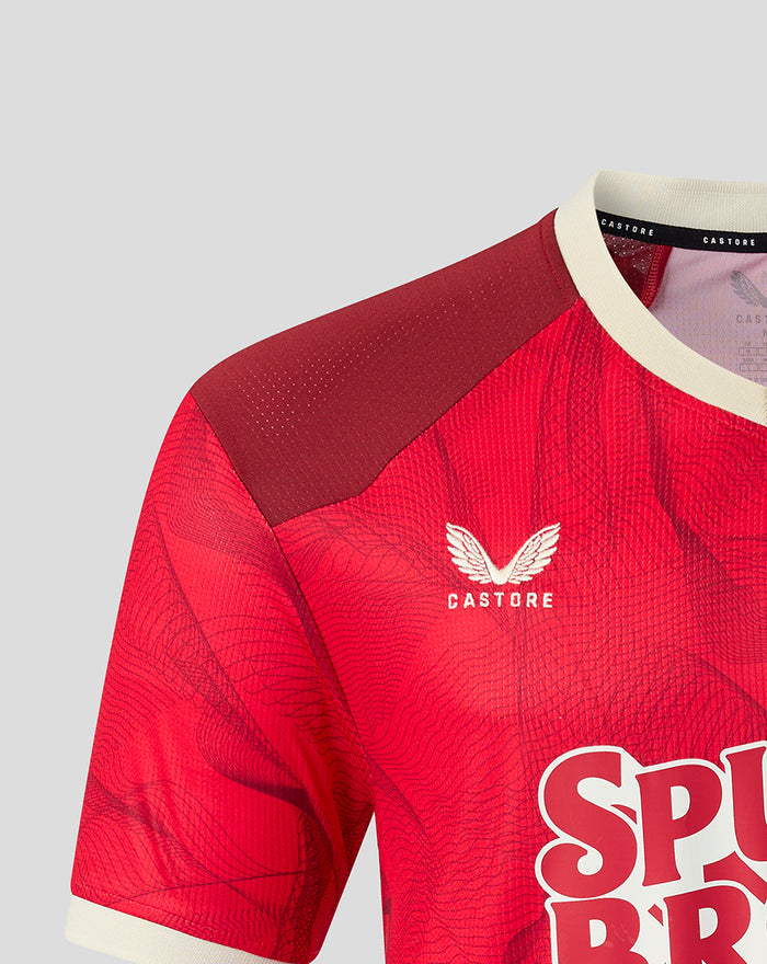 Close up of the red PNE 2026/27 third short sleeve shirt showing crest on chest and maroon shoulder panel with cream collar.