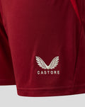 Close-up of maroon shorts showing the white Castore wing logo and CASTORE lettering near the hem