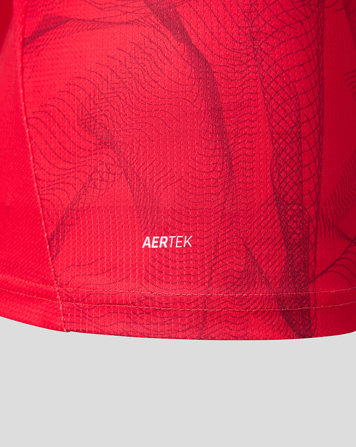 Close-up of red fabric showing AERTEK branding near the hem with a subtle wavy pattern