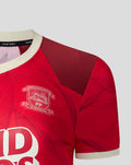 Chest close-up showing crest and large sponsor graphic on the red patterned PNE shirt